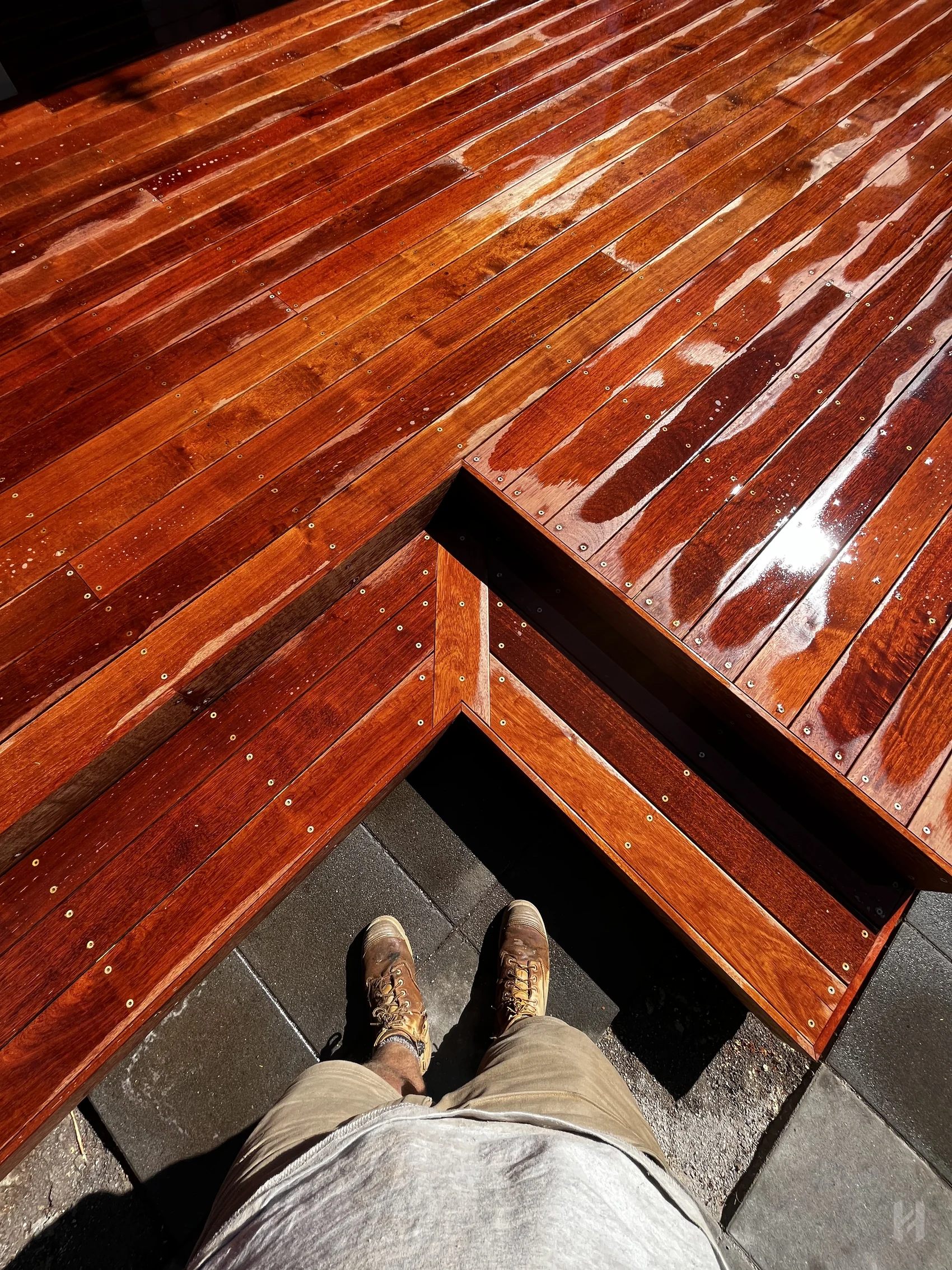 Mitred timber deck corner with glossy finish and tight carpentry detail