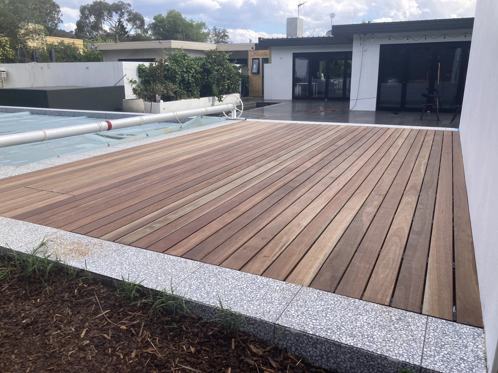 Poolside timber deck detail with clean board lines and landscaped edge