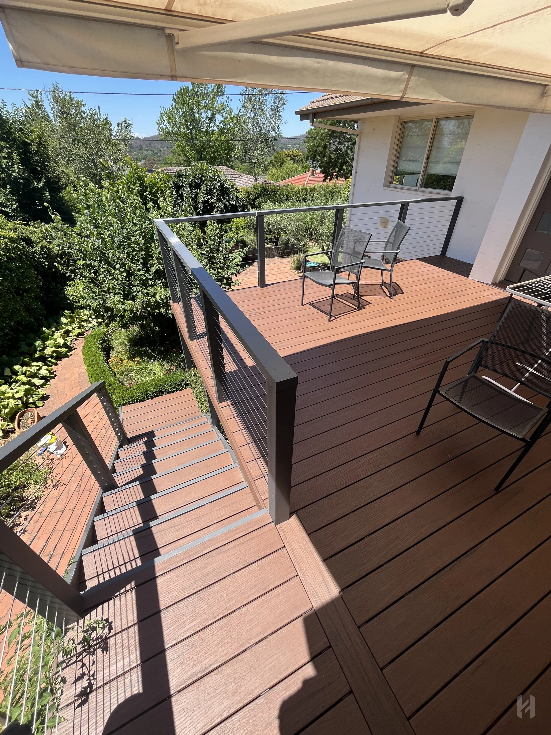 Composite decking Canberra project with black-framed balustrade and outdoor seating